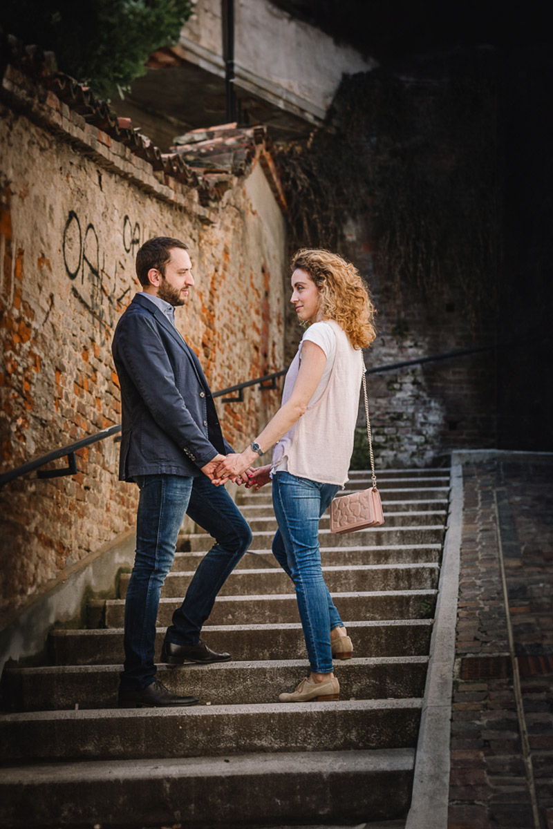 Prematrimoniale nel centro medievale di Chieri. Giulia e Domenico si tengono per mano.