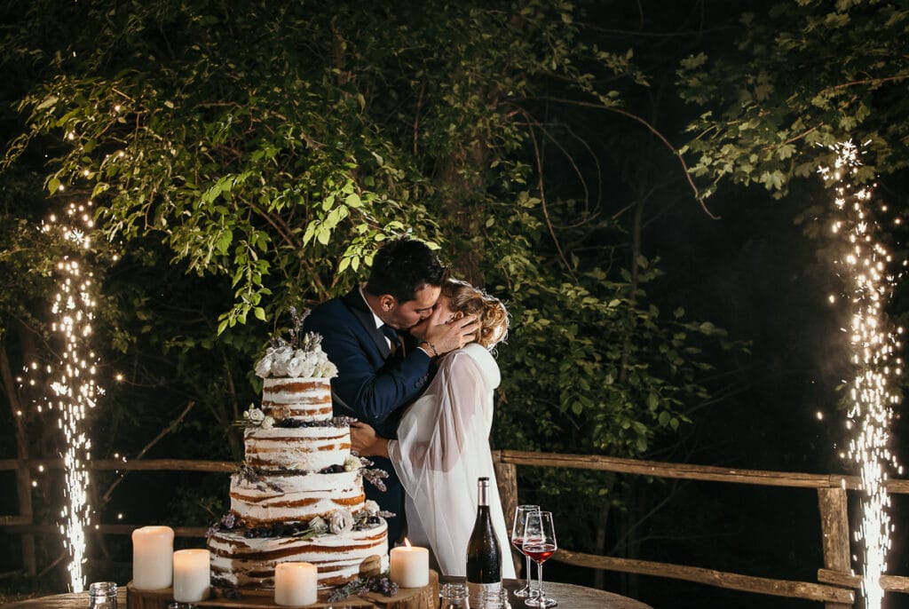 Matrimonio shabby chic a Villa Delfini di Morsasco in Monferrato. Taglio torta serale. Naked cake e fontane luminose. Bacio degli sposi