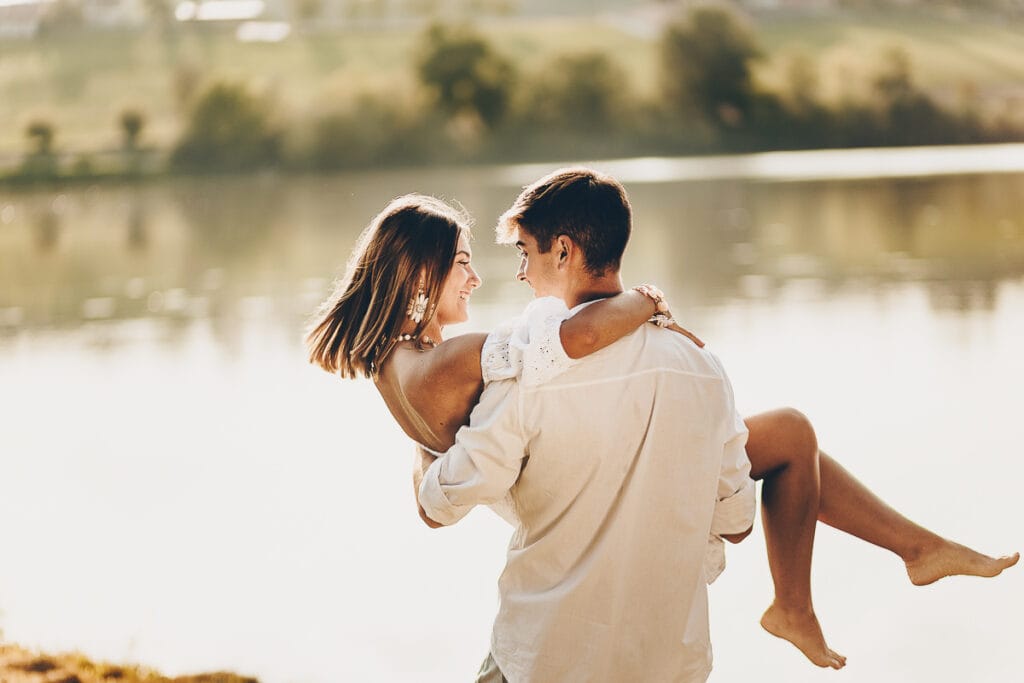 Wedding photographer in Chieri. Marriage proposal at Lake Arignano at sunset. The man picks up the woman in his arms.