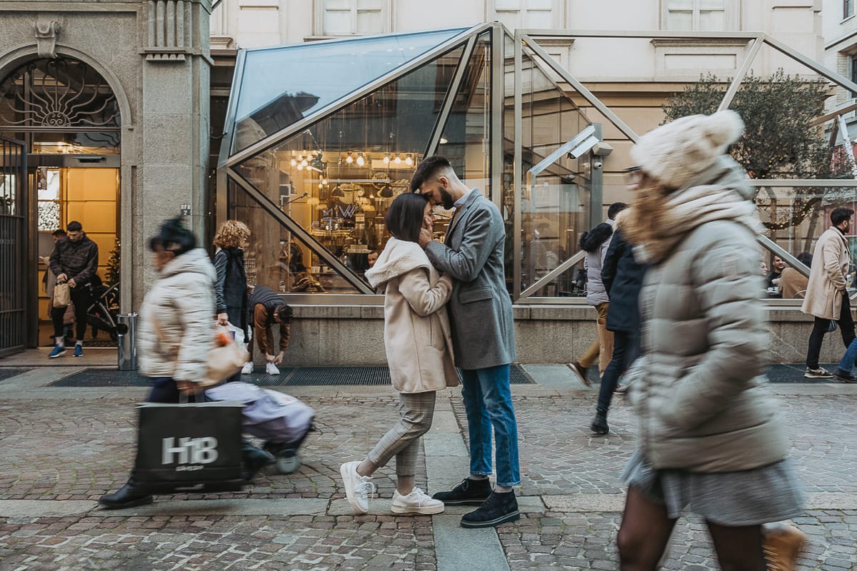 Servizio fotografico di coppia natalizio nel centro di Torino. Coppia nella via davanti alla Rinascente. Mosso creativo.