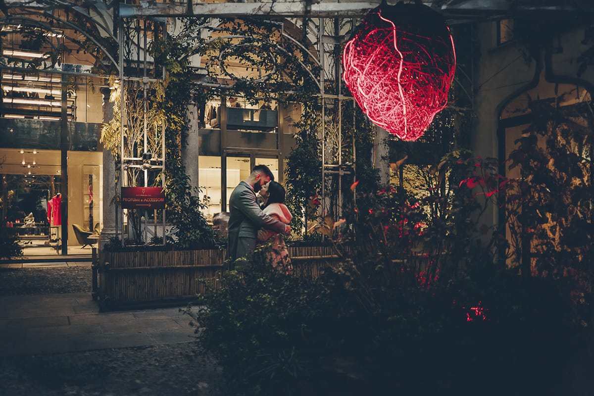 Servizio fotografico di coppia natalizio nel centro di Torino. Coppia nel cortile della Boutique San Carlo dal 1973.