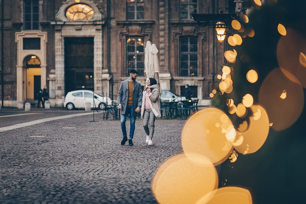 Servizio fotografico di coppia natalizio nel centro di Torino. Coppia in piazza Carignano con le luci natalizie che creano il bokeh.