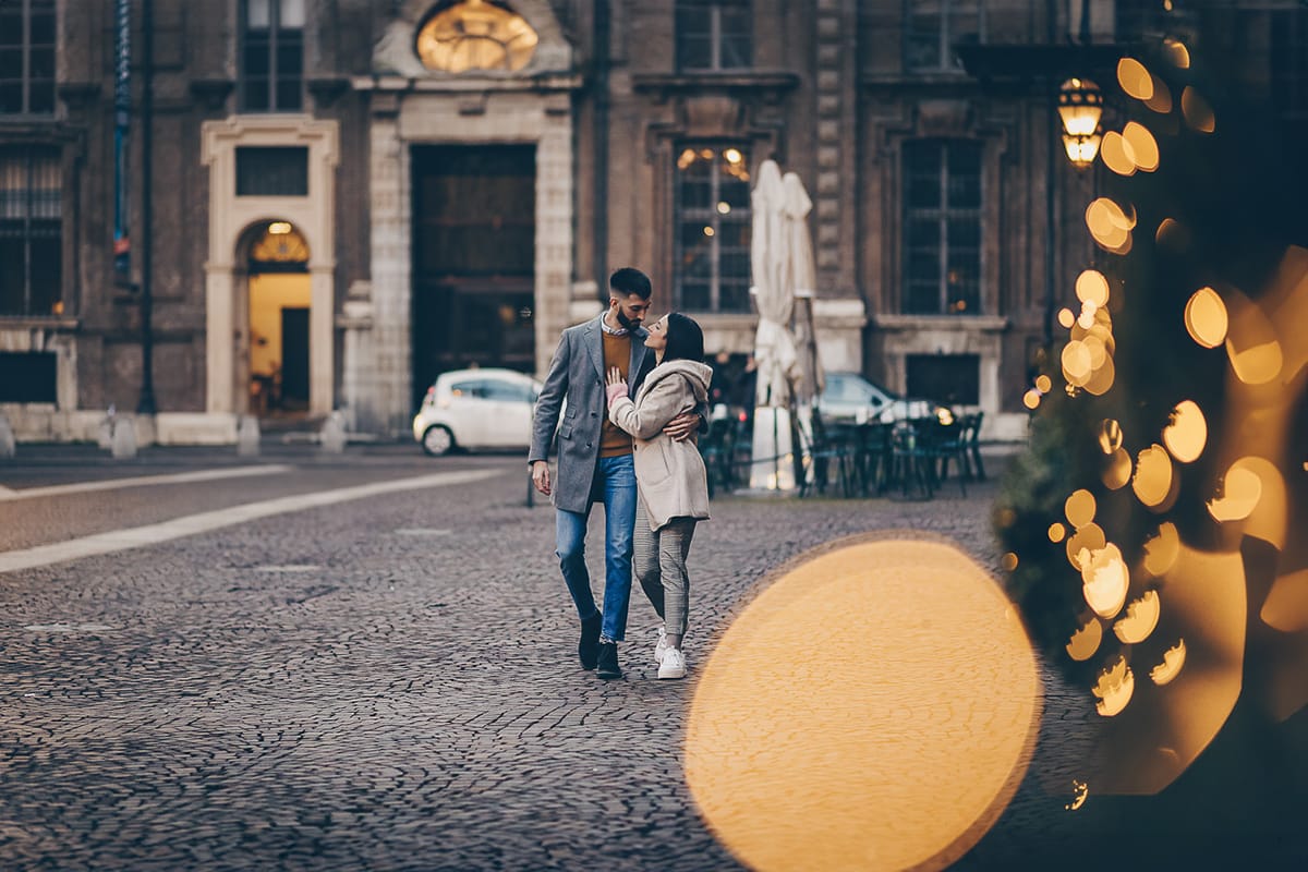 Servizio fotografico di coppia natalizio nel centro di Torino. Coppia in piazza Carignano con le luci natalizie che creano il bokeh.