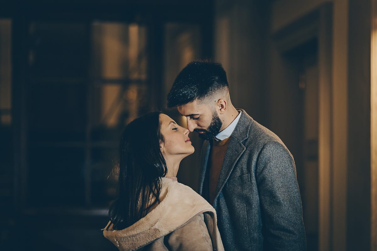 Servizio fotografico di coppia natalizio nel centro di Torino. Coppia in piazza Carignano nell'androne di un palazzo addobbato per Natale.