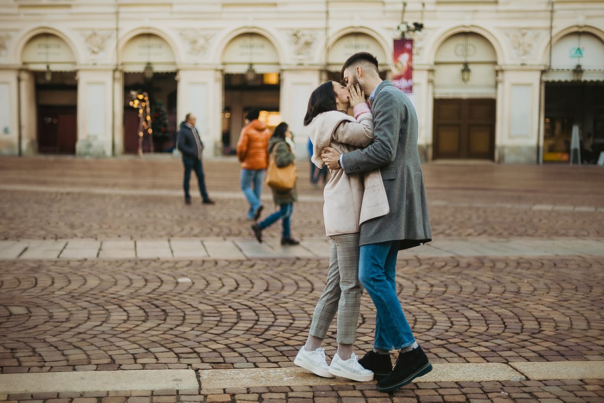 Servizio fotografico di coppia natalizio nel centro di Torino. Bacio di Paola e Martino in piazza San Carlo.