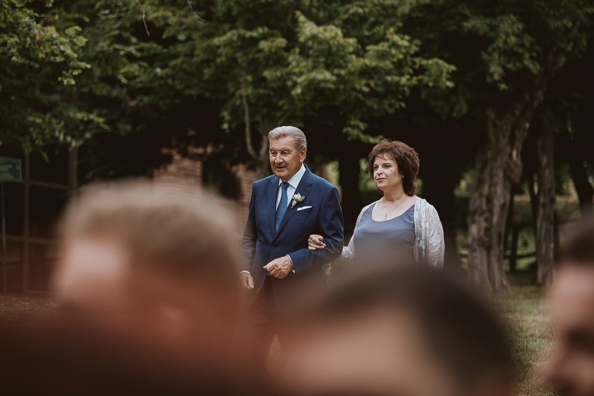 Destination wedding al Relais Sant'Uffizio. Cerimonia. Entrata del padre dello sposo con la madre della sposa.