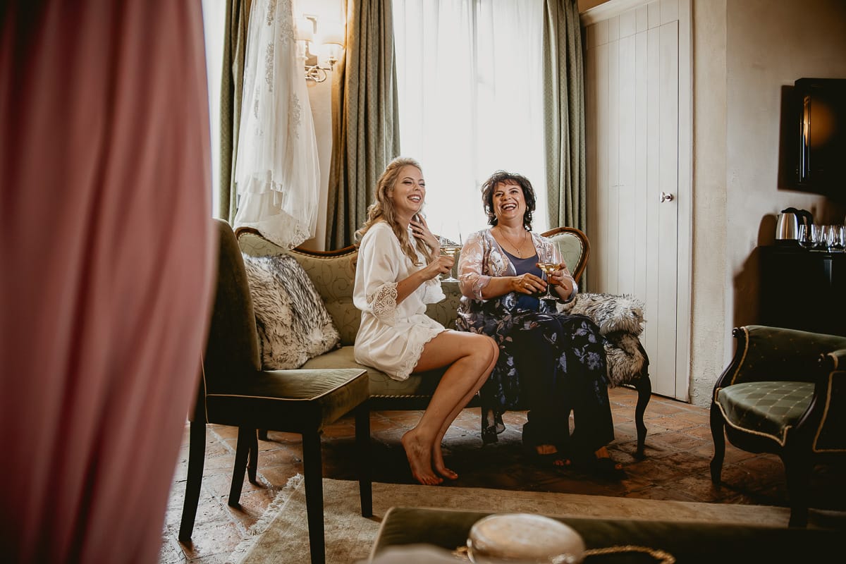 Destination wedding al Relais Sant'Uffizio. Preparazione della sposa. Sposa seduta su di un divanetto con la mamma.