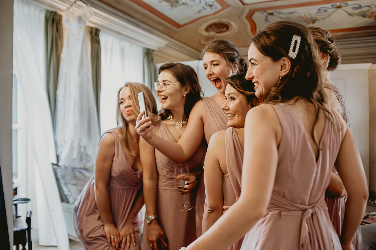Destination wedding al Relais Sant'Uffizio. Preparazione della sposa. Damigelle si guardano allo specchio.