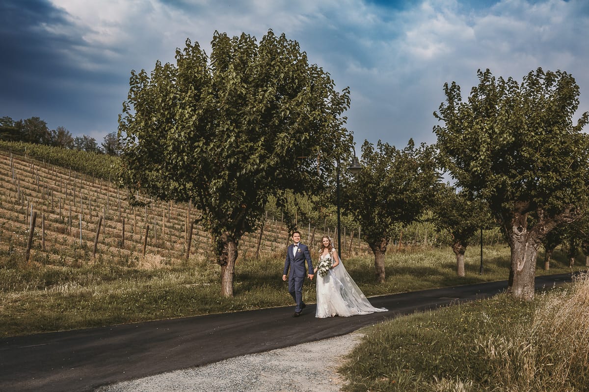 Destination wedding al Relais Sant'Uffizio. Sessione fotografica di coppia. Sposi camminano tra le vigne.