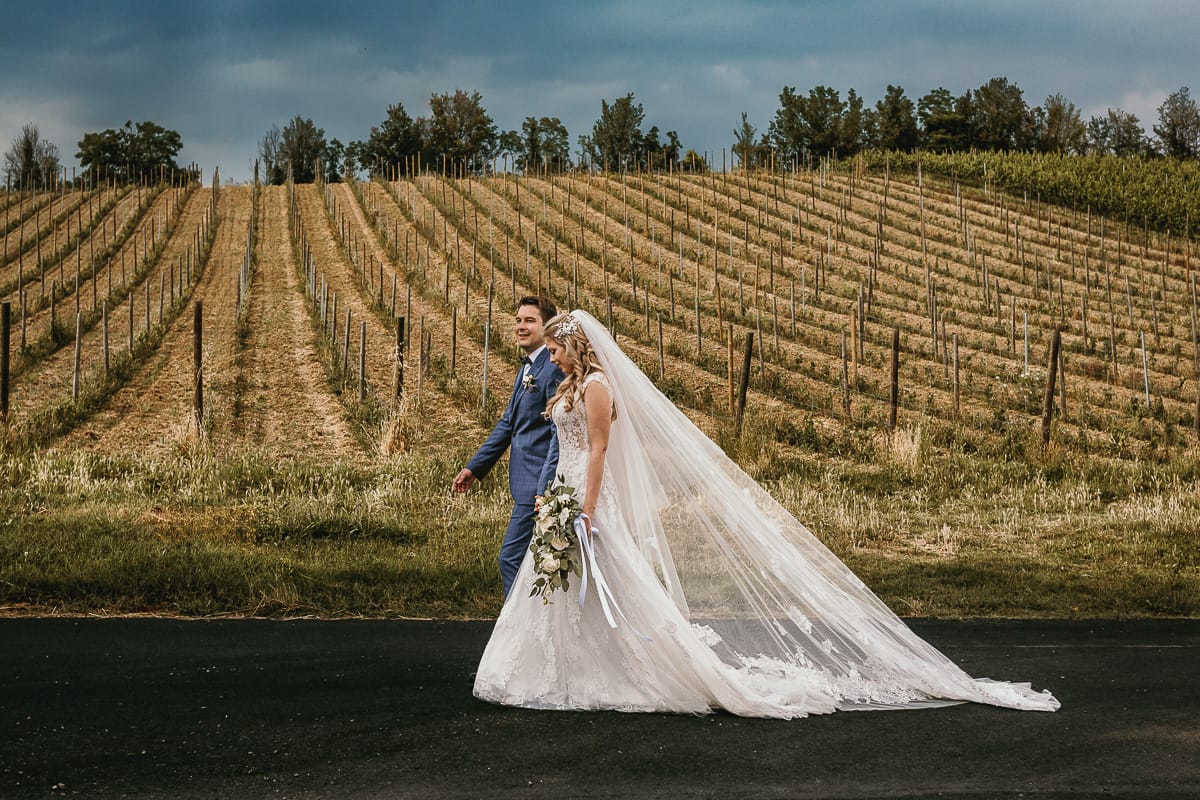 Destination wedding al Relais Sant'Uffizio. Sessione fotografica di coppia. Sposi camminano tra le vigne.