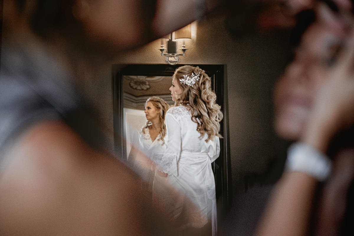 Destination wedding al Relais Sant'Uffizio. Preparazione della sposa. Sposa che si guarda nello specchio.
