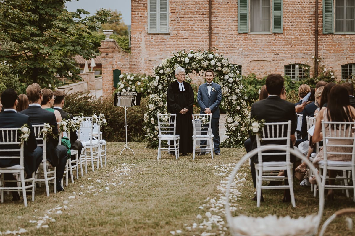 Destination wedding al Relais Sant'Uffizio. Cerimonia.Sposo aspetta la sposa e conversa con il pastore protestante.