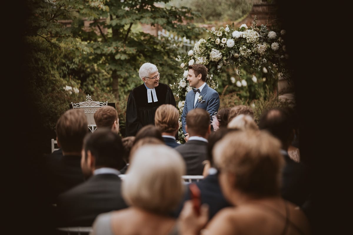Destination wedding al Relais Sant'Uffizio. Cerimonia.Sposo aspetta la sposa e conversa con il pastore protestante.