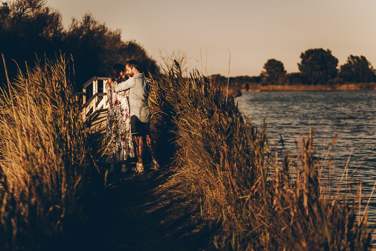 Servizio fotografico di coppia nella Laguna del Delta del Po al tramonto. Diego e Serena sul ponticello di legno