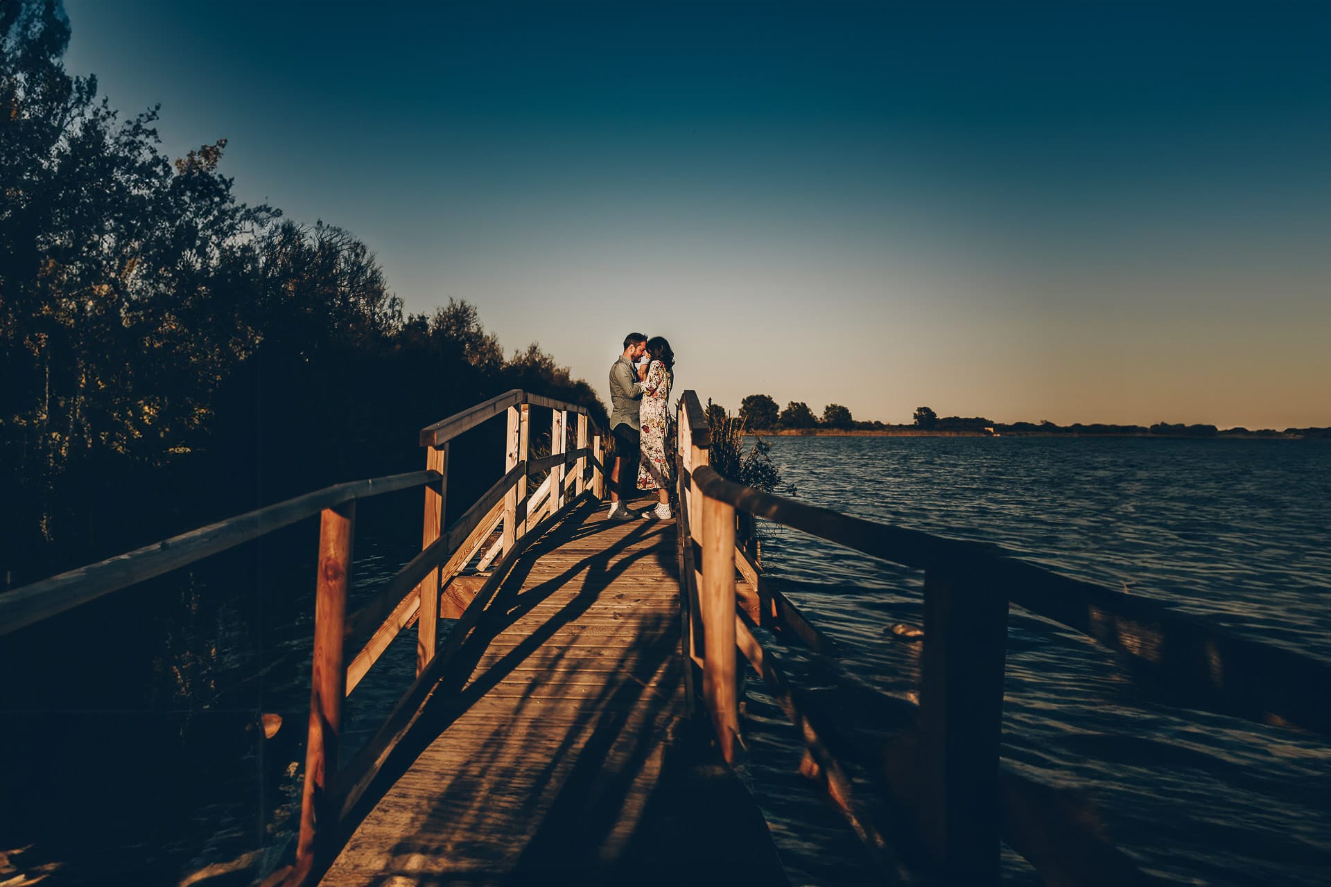 Servizio fotografico di coppia nella Laguna del Delta del Po al tramonto. Coppia sul ponticello di legno