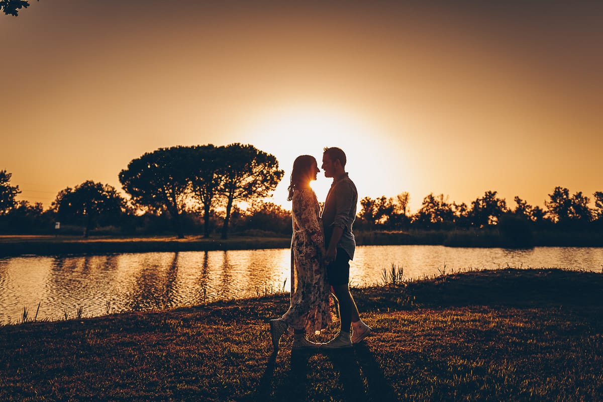 Servizio fotografico di coppia nella Laguna del Delta del Po al tramonto. Silhouette e sole tra la coppia.