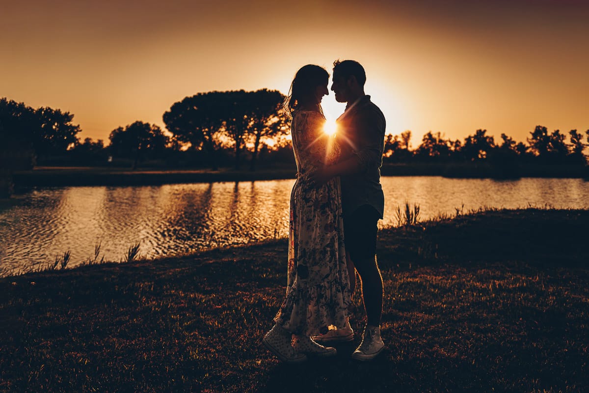 Servizio fotografico di coppia nella Laguna del Delta del Po al tramonto. Silhouette e sole tra la coppia.
