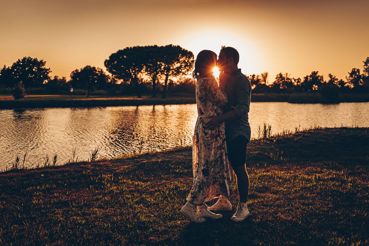 Servizio fotografico di coppia nella Laguna del Delta del Po al tramonto. Silhouette e sole tra la coppia.