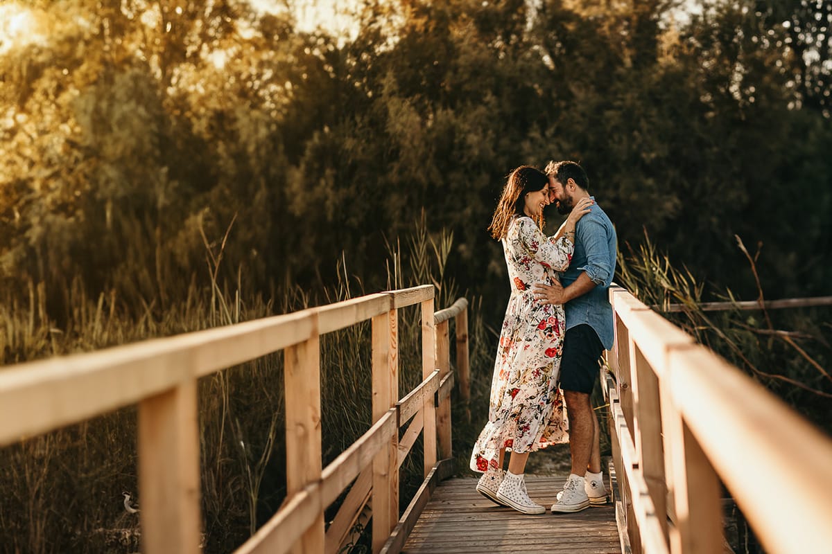 Servizio fotografico di coppia nella Laguna del Delta del Po al tramonto. Diego e Serena sul ponticello di legno fra i canneti