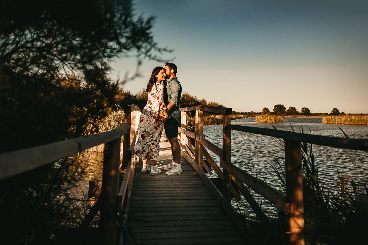 Servizio fotografico di coppia nella Laguna del Delta del Po al tramonto. Diego e Serena sul ponticello di legno