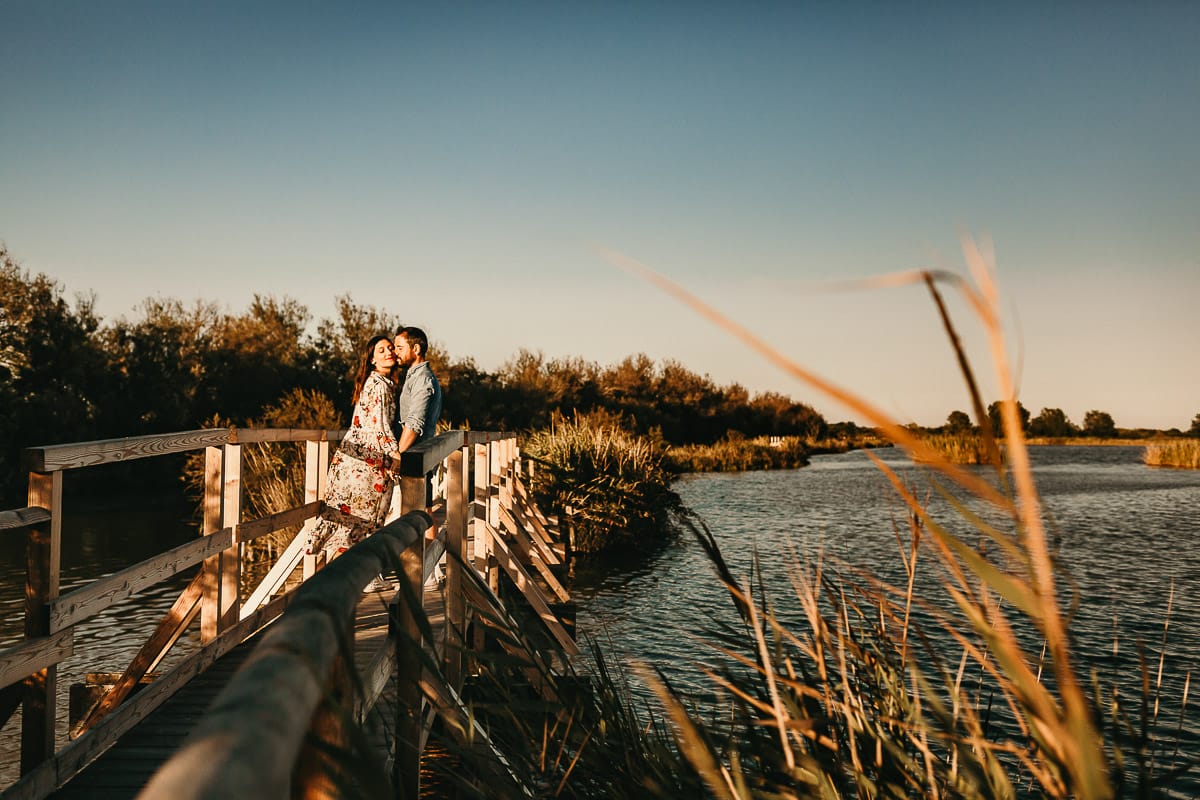 Servizio fotografico di coppia nella Laguna del Delta del Po al tramonto. Diego e Serena sul ponticello di legno