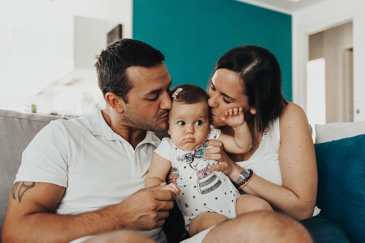 Fotografia di famiglia a Chieri. La piccola Aurora in braccio al papà e alla mamma
