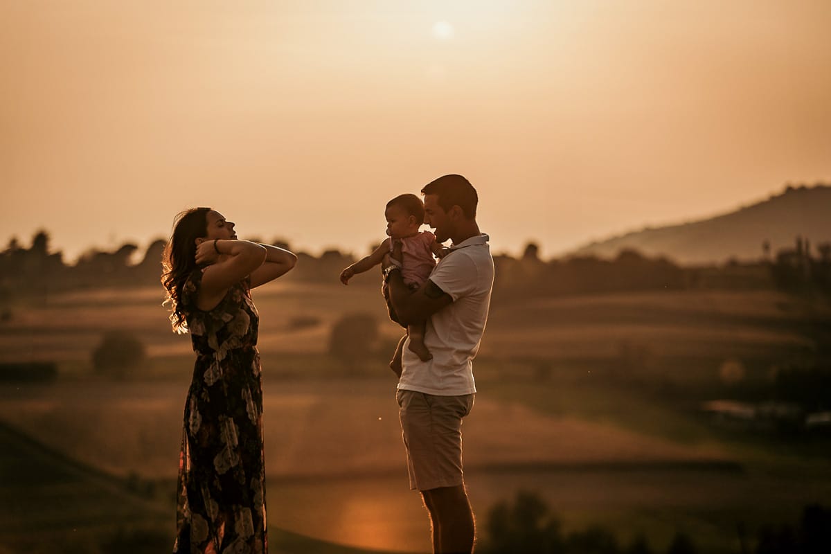 Fotografia di famiglia a Chieri. Ritratti spontanei in esterno nelle colline intorno alla città, al tramonto. Silhouette