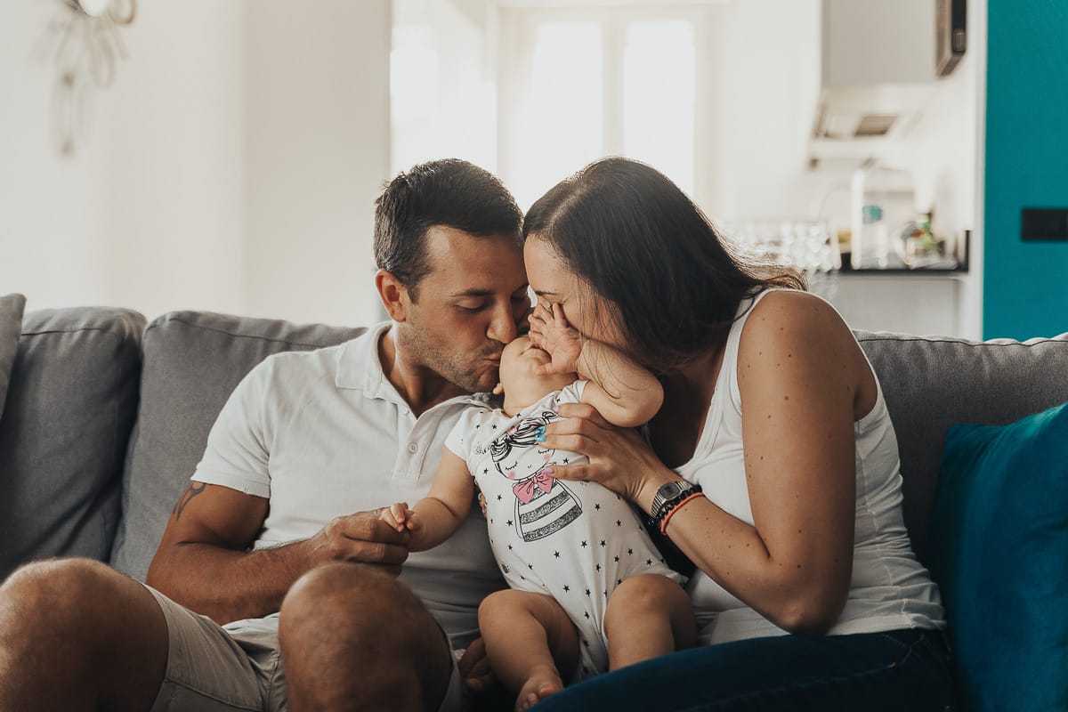Fotografia di famiglia a Chieri. La piccola Aurora in braccio al papà e alla mamma