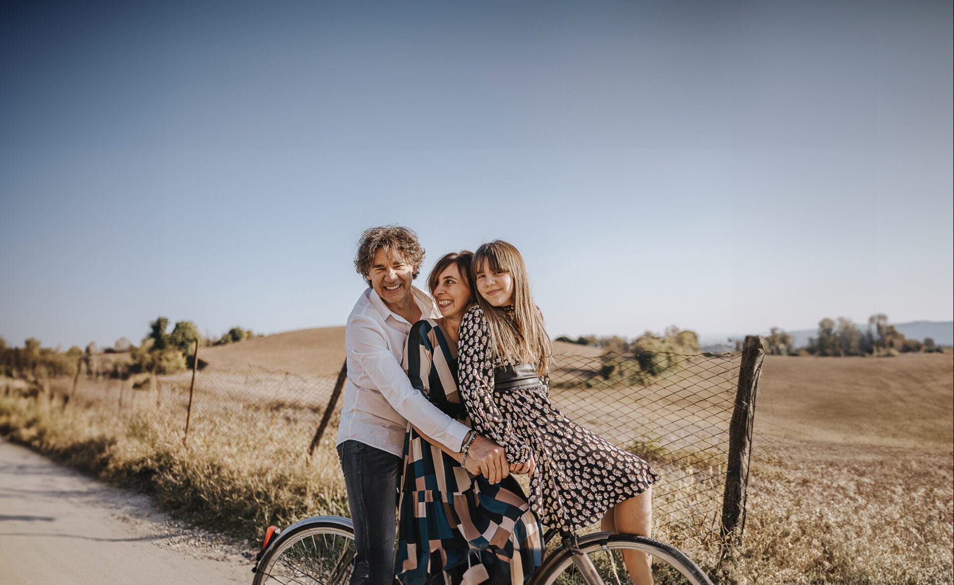 Servizio fotografico di famiglia a Mombello di Torino, in autunno. la famiglia è su di una bicicletta in mezzo ai camoi