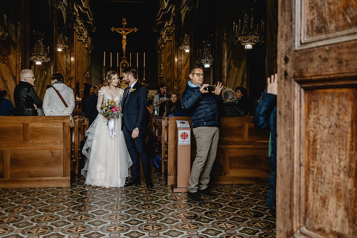 Matrimonio sotto la pioggia a Cambiano. Cerimonia. Uscita degli sposi con i partecipanti alla messa successiva che si fanno i selfie incuranti degli sposi