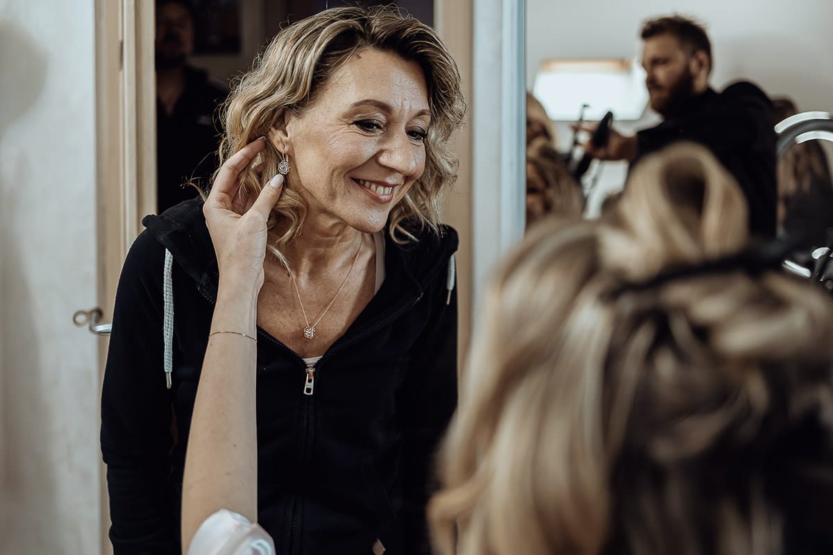 Matrimonio sotto la pioggia a Cambiano. preparazione della sposa. Sposa tocca l'orecchino alla mamma