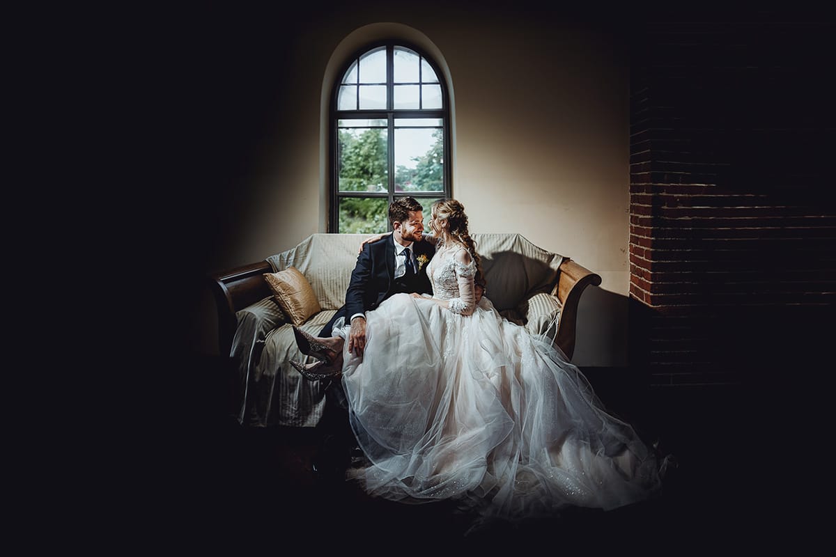 Matrimonio sotto la pioggia a Tenuta Tamburnin di Castelnuovo Don Bosco. Ritratto degli sposi seduti su di un divano ottocentesco