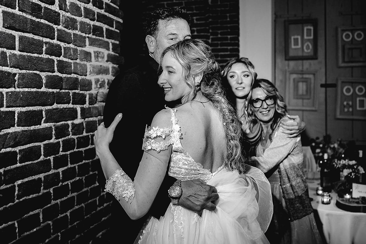 Matrimonio sotto la pioggia a Tenuta Tamburnin di Castelnuovo Don Bosco. Cena. Sposa balla col padre. mamma e sorella li guardano