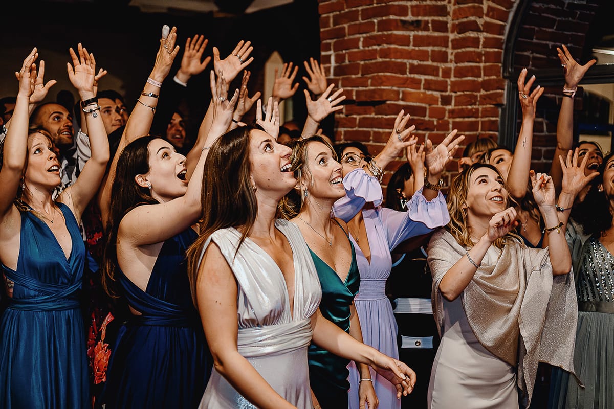Matrimonio sotto la pioggia a Tenuta Tamburnin di Castelnuovo Don Bosco. Cena.lancio del bouquet. ragazze aspettano alzando le mani