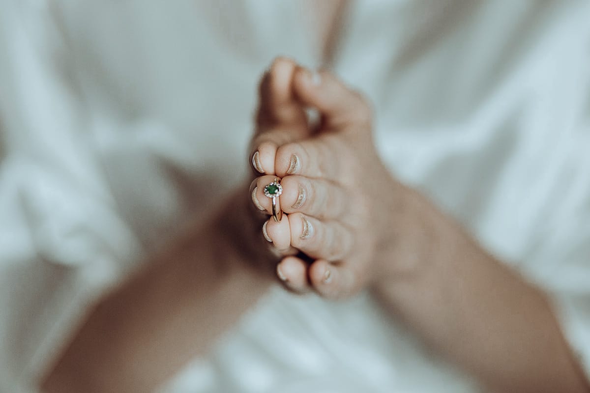 Matrimonio sotto la pioggia a Cambiano. preparazione della sposa. dettaglio dell'anello di fidanzamento tra le mani