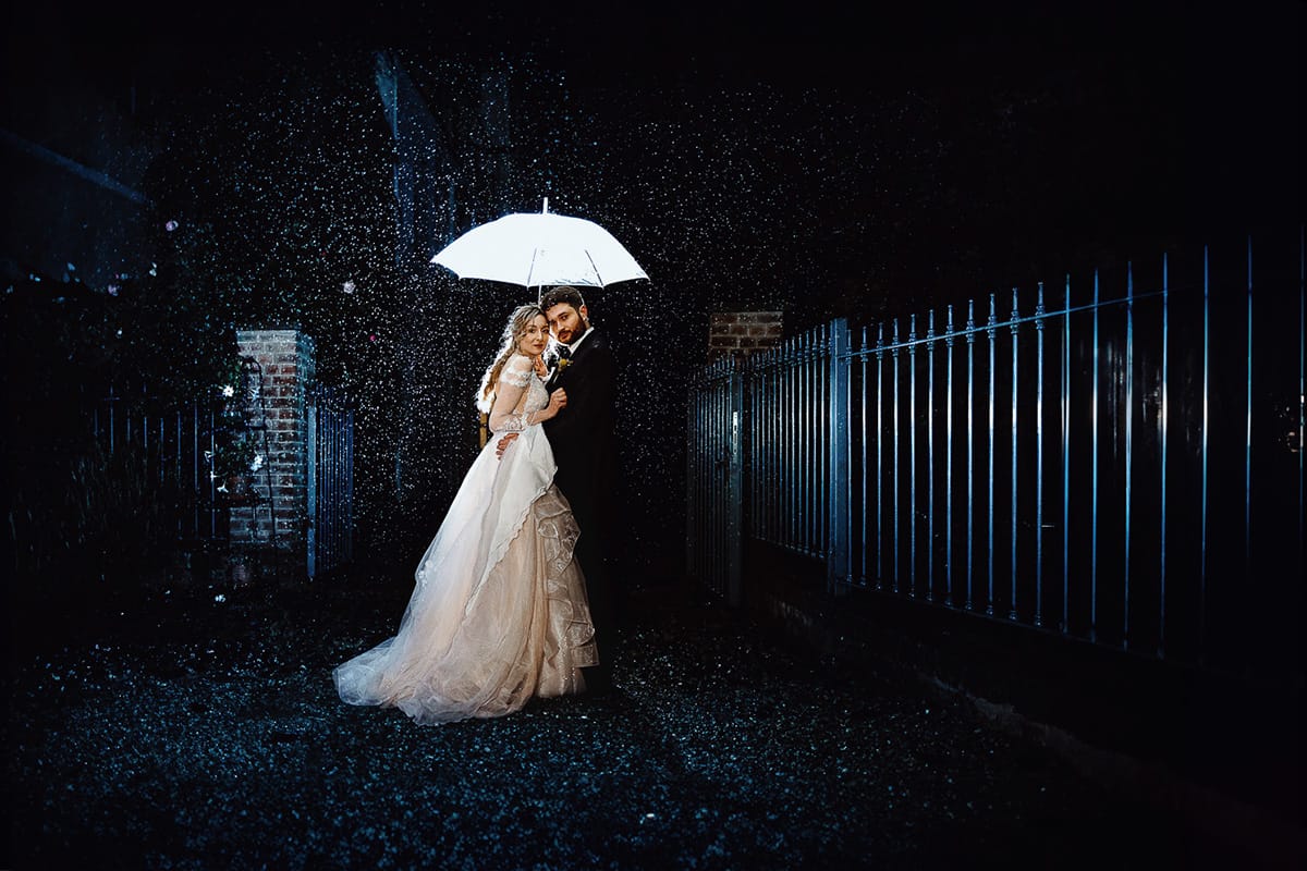 Matrimonio sotto la pioggia a Tenuta Tamburnin di Castelnuovo Don Bosco. Ritratto notturno degli sposi sotto la pioggia. Flas esterno che illumina le gocce di pioggia e crea uno scatto magico