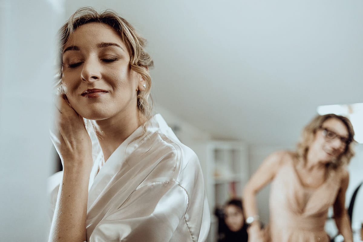 Matrimonio sotto la pioggia a Cambiano. preparazione della sposa.Sposa indossa gli orecchini