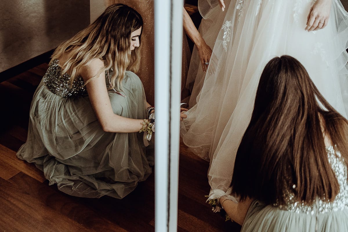 Matrimonio sotto la pioggia a Cambiano. preparazione della sposa.Damigelle mettono le scarpe alla sposa