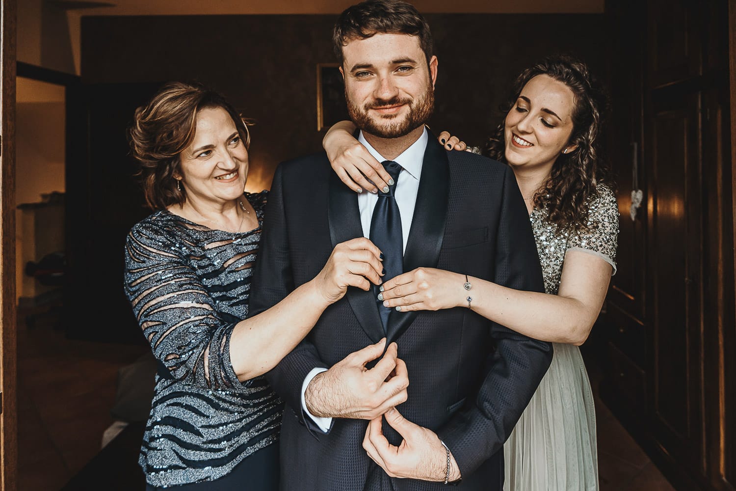 Matrimonio a Cambiano. Preparazione dello sposo. Mamma e sorella aiutano lo sposo
