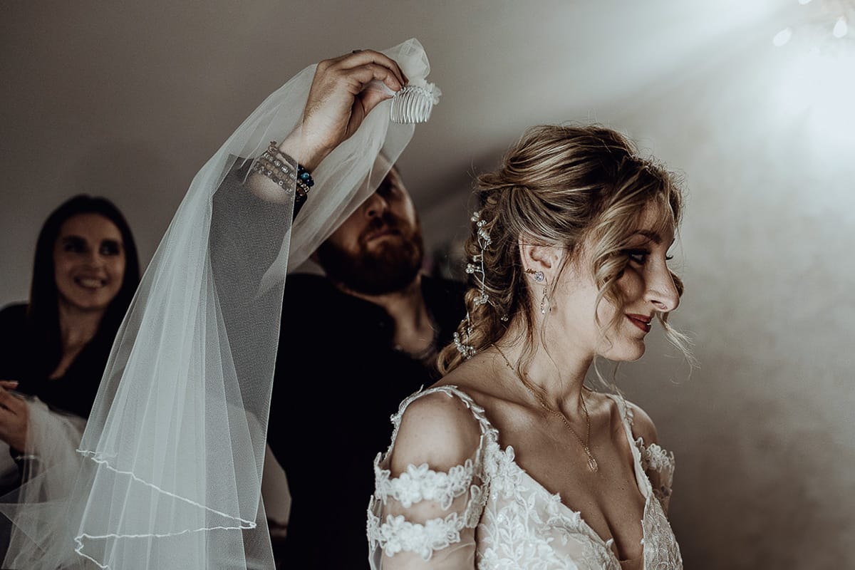 Matrimonio sotto la pioggia a Cambiano. preparazione della sposa. Parrucchiere mette il velo alla sposa
