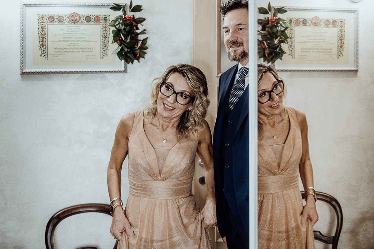 Matrimonio sotto la pioggia a Cambiano. preparazione della sposa. Genitori guardano la sposa con l'abito da sposa