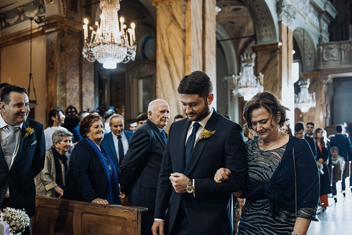 Matrimonio sotto la pioggia a Cambiano. Cerimonia. Entrata dello sposo al braccio della mamma