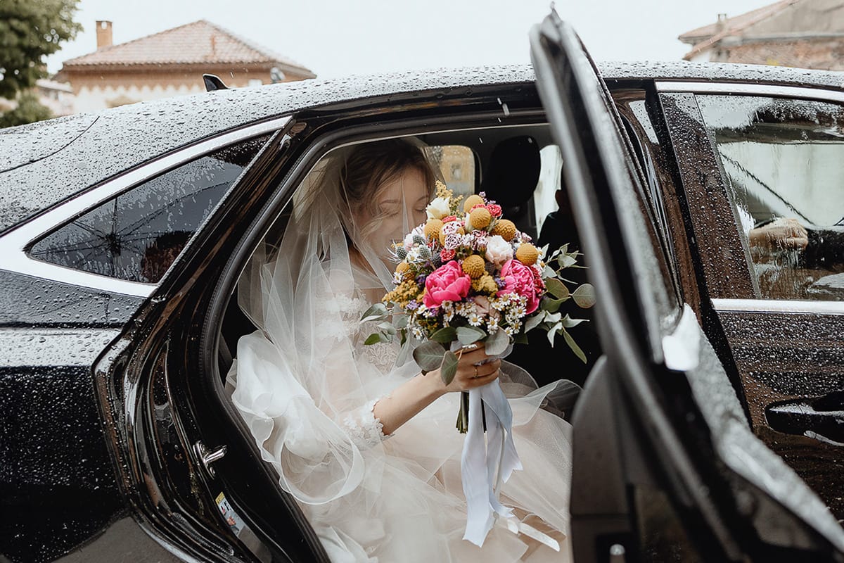 Matrimonio sotto la pioggia a Cambiano. Cerimonia. Sposa esce dall'auto