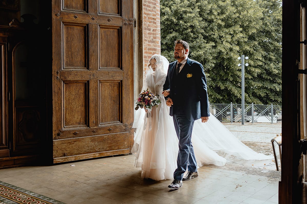 Matrimonio sotto la pioggia a Cambiano. Cerimonia. Entrata della sposa al braccio del padre