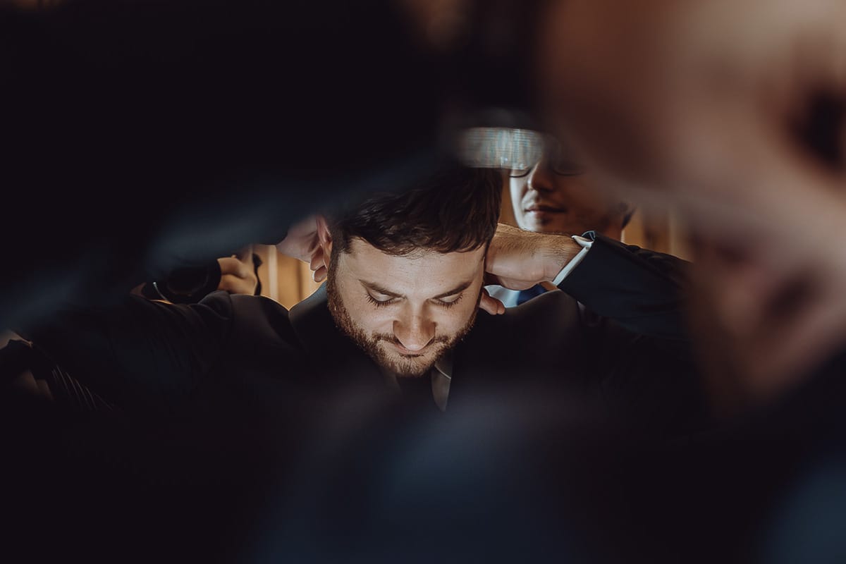 Matrimonio a Cambiano. Preparazione dello sposo. Sposo si sistema la cravatta