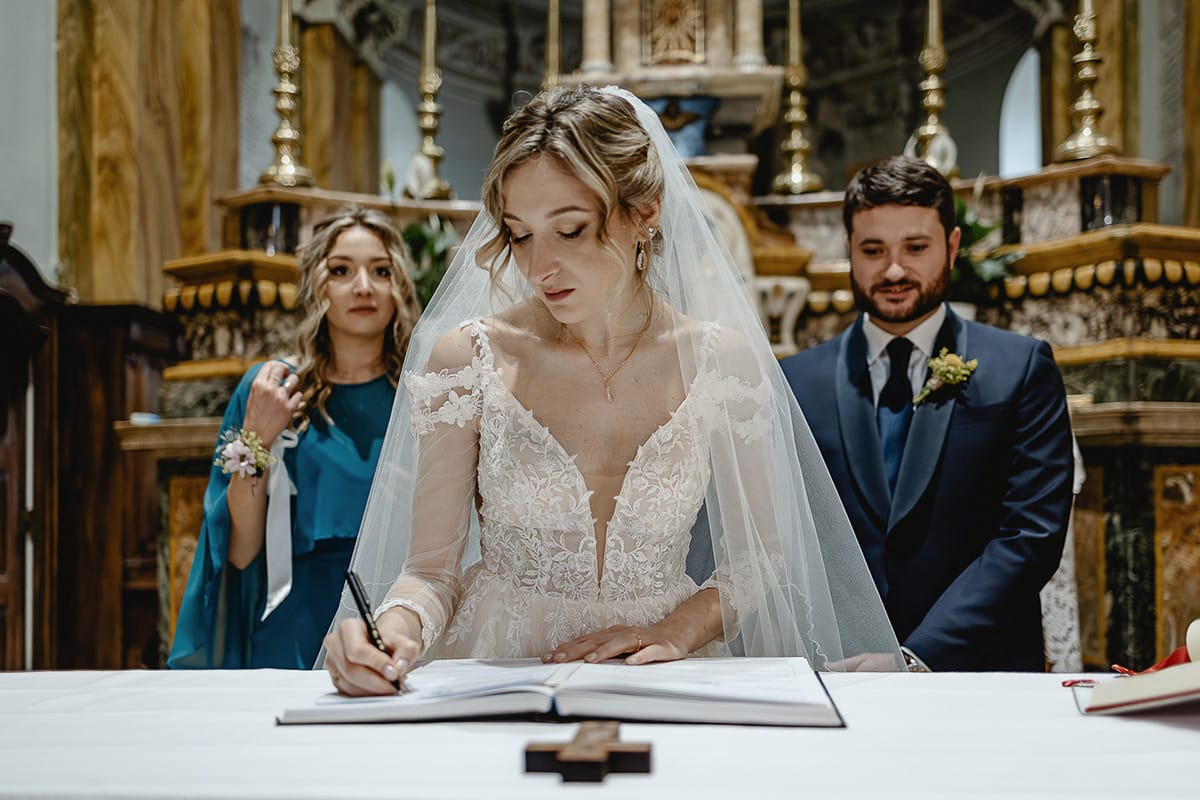 Matrimonio sotto la pioggia a Cambiano. Cerimonia. Sposa firma