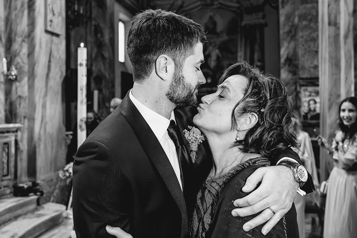 Matrimonio sotto la pioggia a Cambiano. Cerimonia. Sposo abbraccia la madre