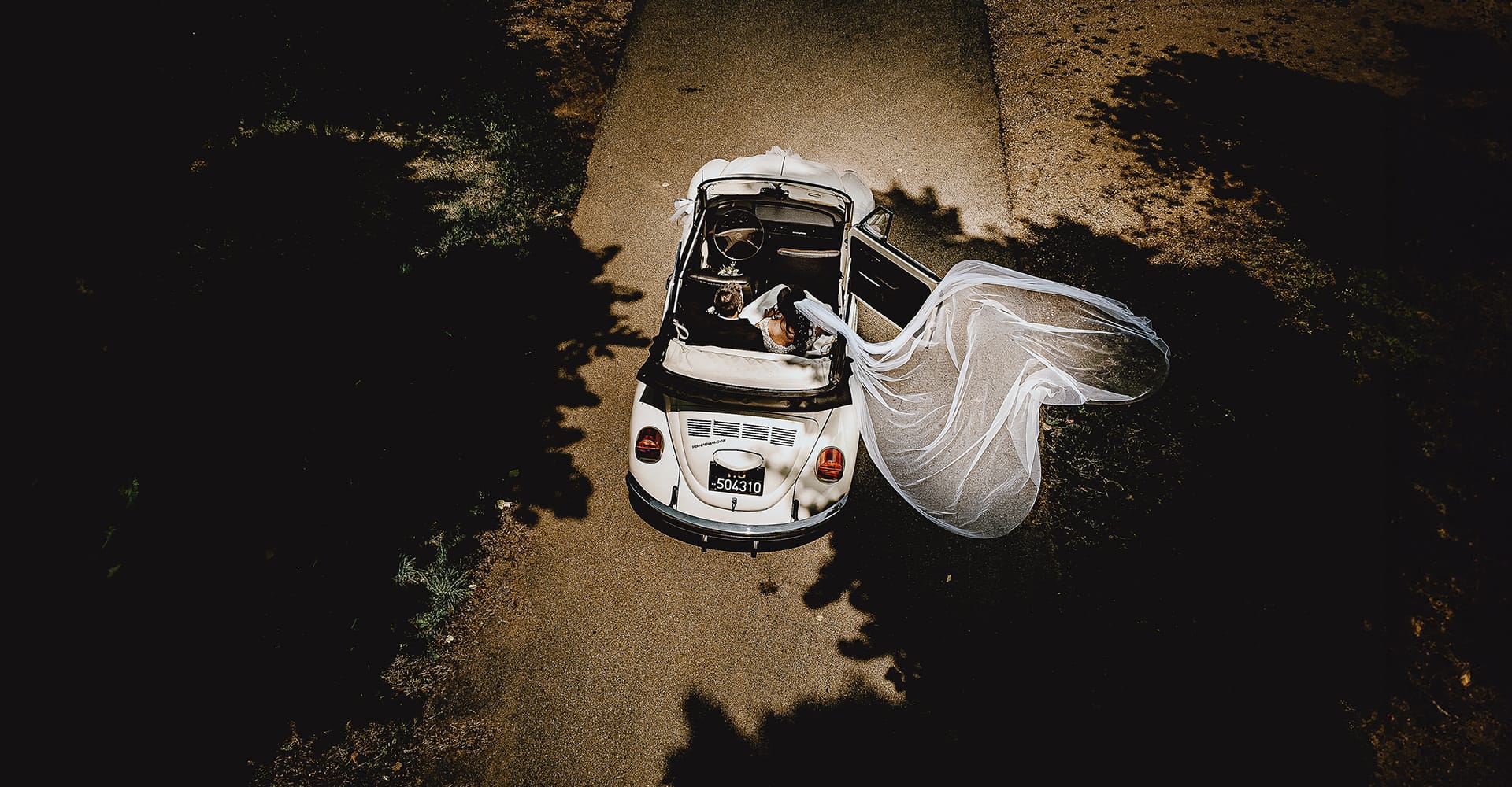 Fotografo matrimonio Chieri, matrimonio a riva presso chieri. Fotogrfia dal drone degli sposi nell'auto scoperta maggiolino Wolkswagen.