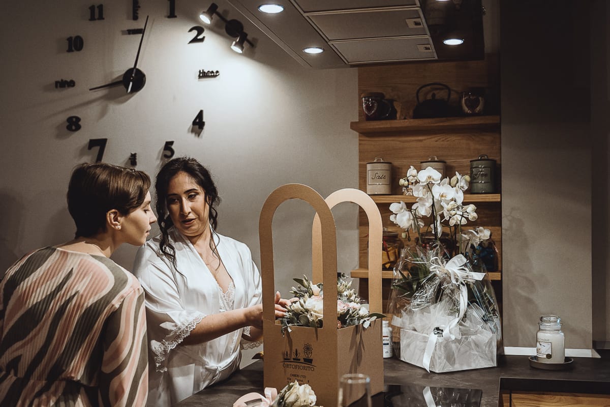 Matrimonio a Riva presso Chieri, preparazione della sposa. Sposa che mostra il bouquet ad un'amica