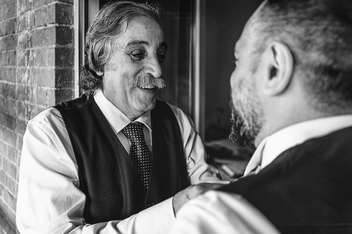 Matrimonio a Riva presso Chieri, preparazione dello sposo. Padre sistema la cravatta dello sposo.